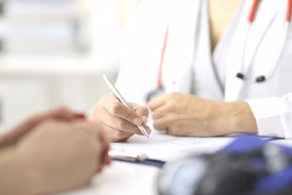 IVF doctor taking notes in the office close-up of patient hands