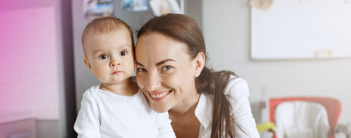 Young female fertility patient posing with her child in the kitchen