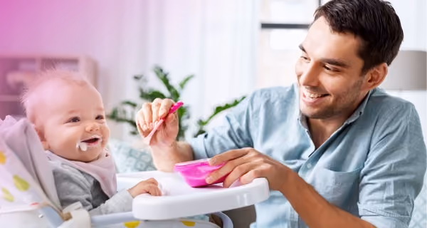 Young father feeds his child