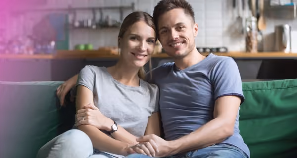 Young heterosexual couple about to start IVF treatment posing smiling in their living room