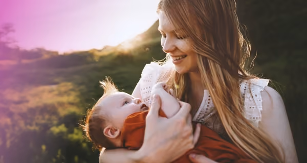 Young mother embraces her child in scenic surroundings