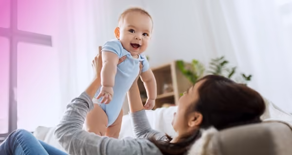 Female fertility patient playing with her baby in the living room