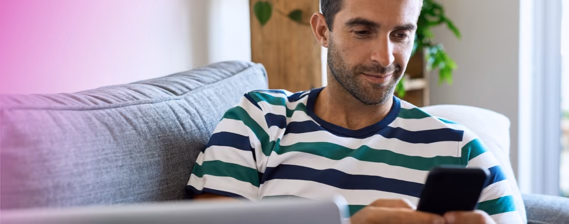 Man in sofa reading about fertility treatment on his mobile phone
