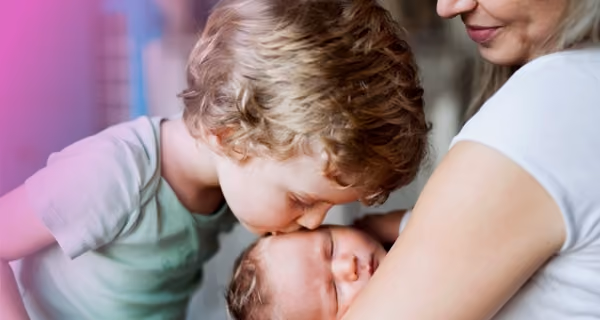 Mother introduces her newborn child to the brother