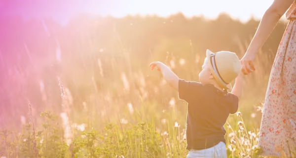 Mother walking with her toddler in a field