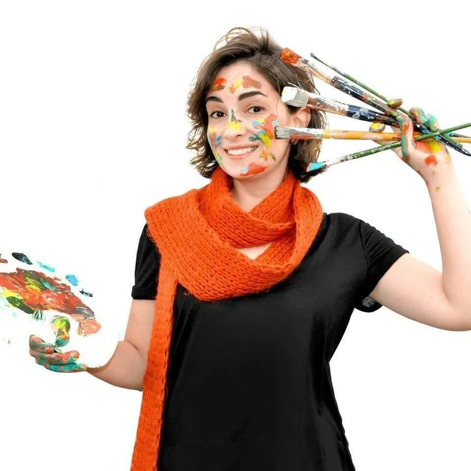 Karine Makartichan, art director and founder of US Illustrations children's book illustration studio, holding paintbrushes