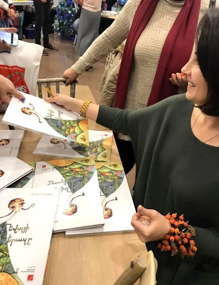 Children's book illustrator signing published picture books at a literary event