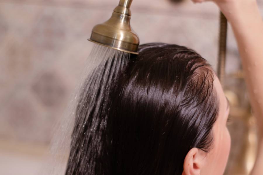Person rinsing hair under shower