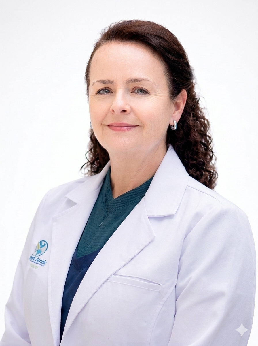 Middle-aged woman with curly brown hair wearing a white medical coat and teal scrubs, smiling gently against a plain white background.