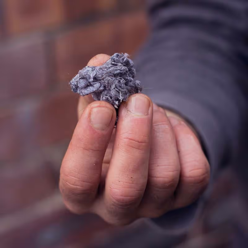 A man holding a dryer vent lint.
