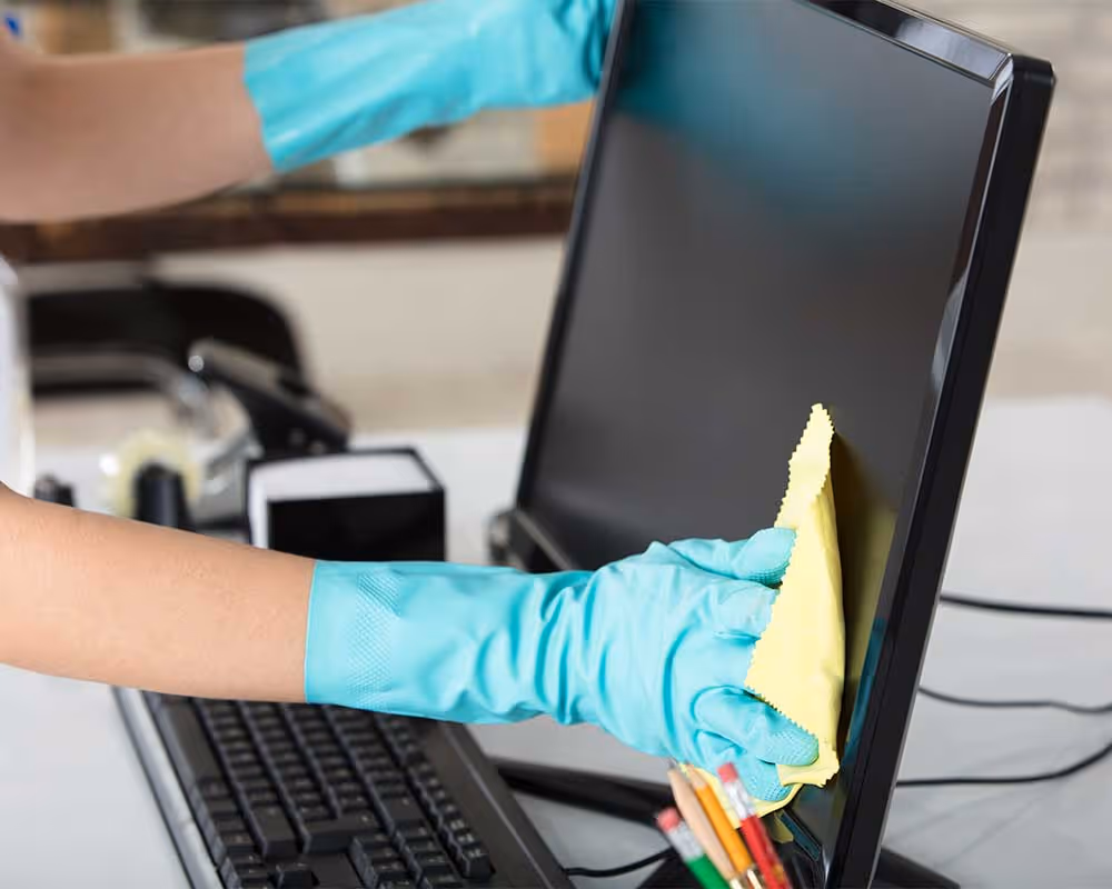 Cleaning desktop monitor in office