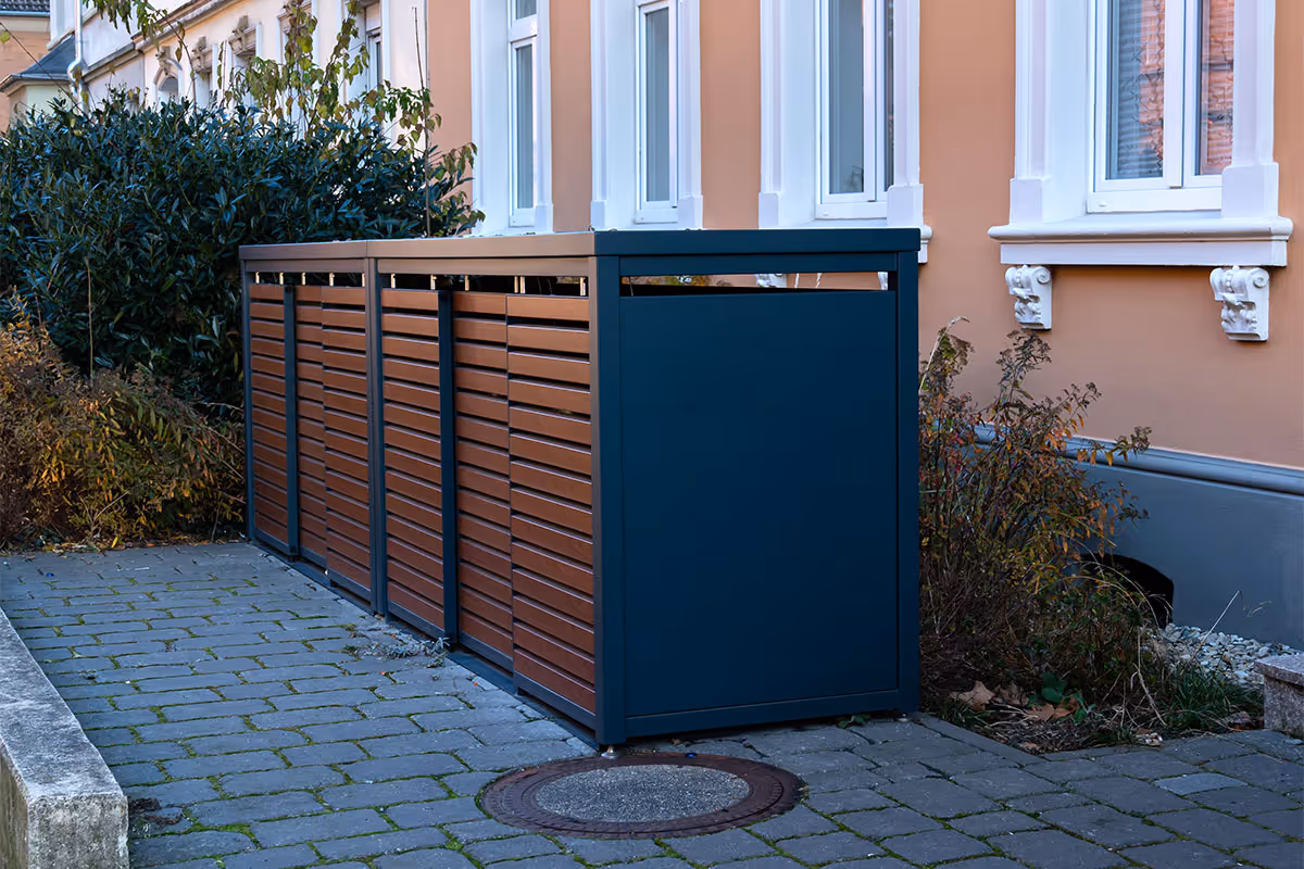 A container with garbage bins inside.