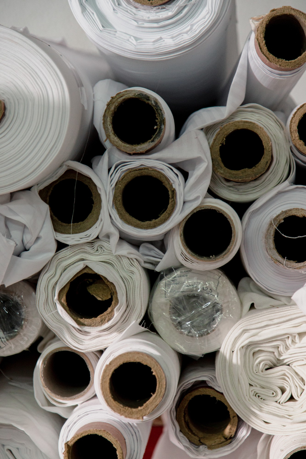 Rolls of white cotton fabric before cutting