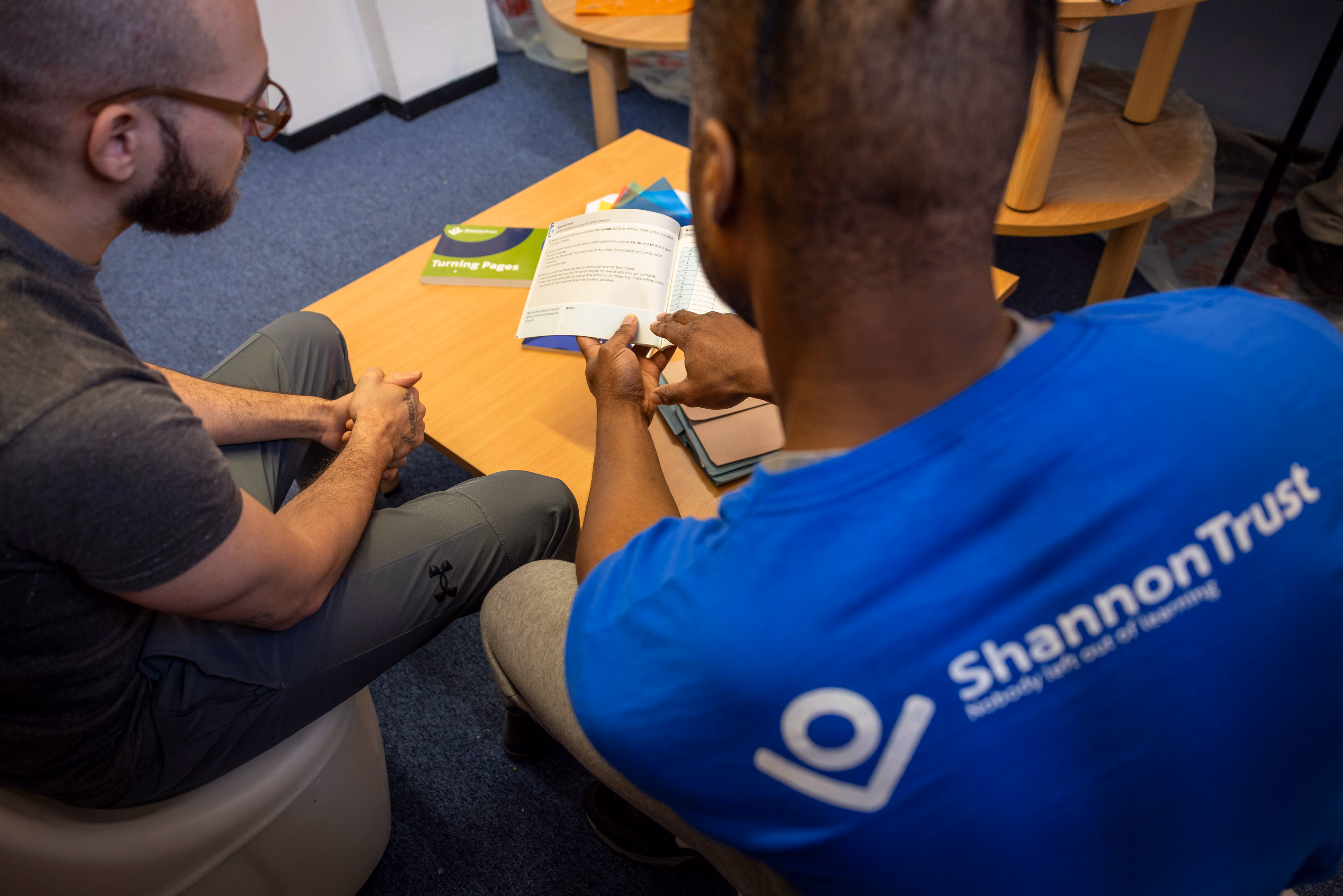 A mentor and a learner going though one of the Turning Pages manuals