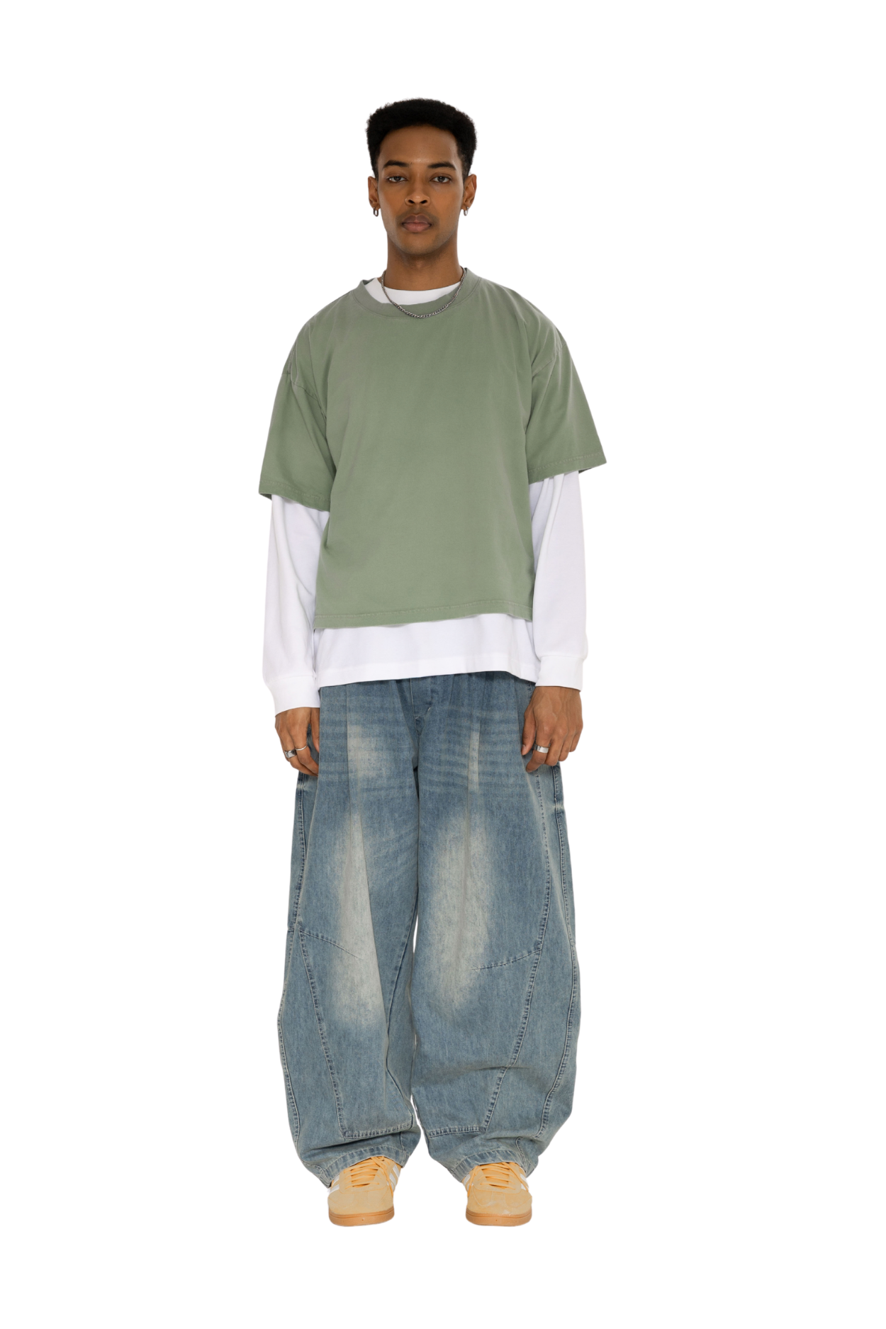 Green washed boxy tee layered over a white long-sleeve tee, with wide-leg jeans