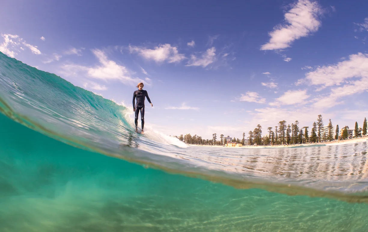 Split shot of a surfer surfing Rote Island