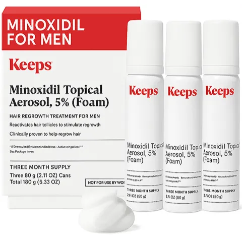 Keeps Minoxidil for Men topical aerosol foam hair regrowth treatment package with three white cans labeled 'Minoxidil Topical Aerosol, 5% (Foam)' and white foam on surface, indicating a three-month supply for hair regrowth.