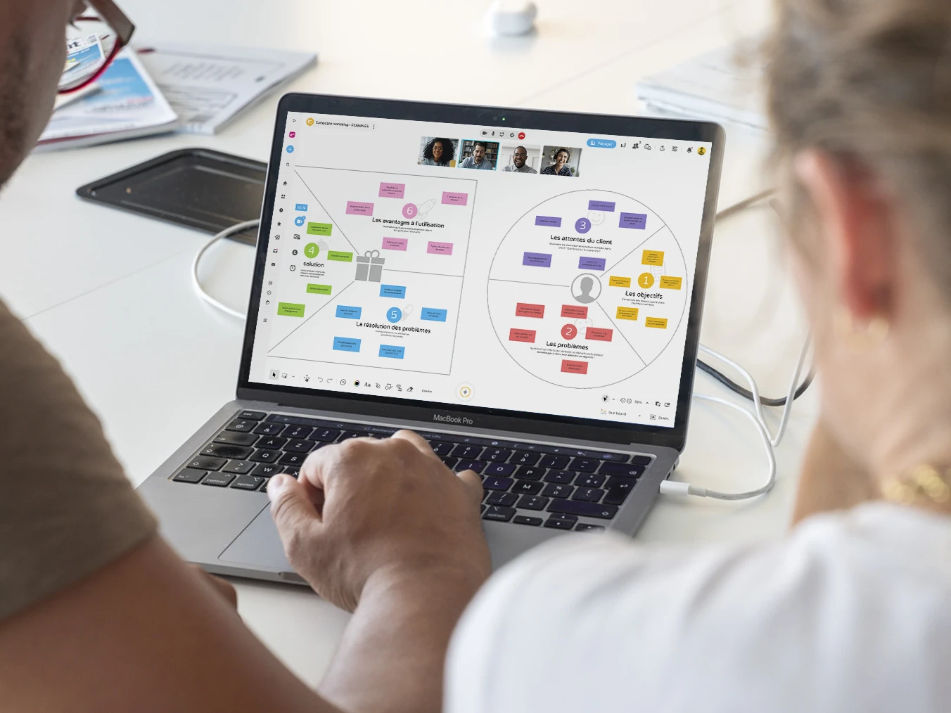 Deux personnes travaillant sur un ordinateur qui affiche un brainstorming sur la proposition de valeur d'une campagne marketing. | Klaxoon