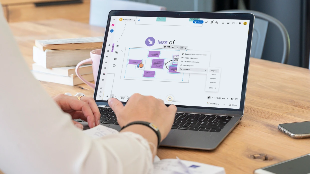 A person working on a computer displaying a Board where ideas are selected to be translated with the help of AI. | Klaxoon