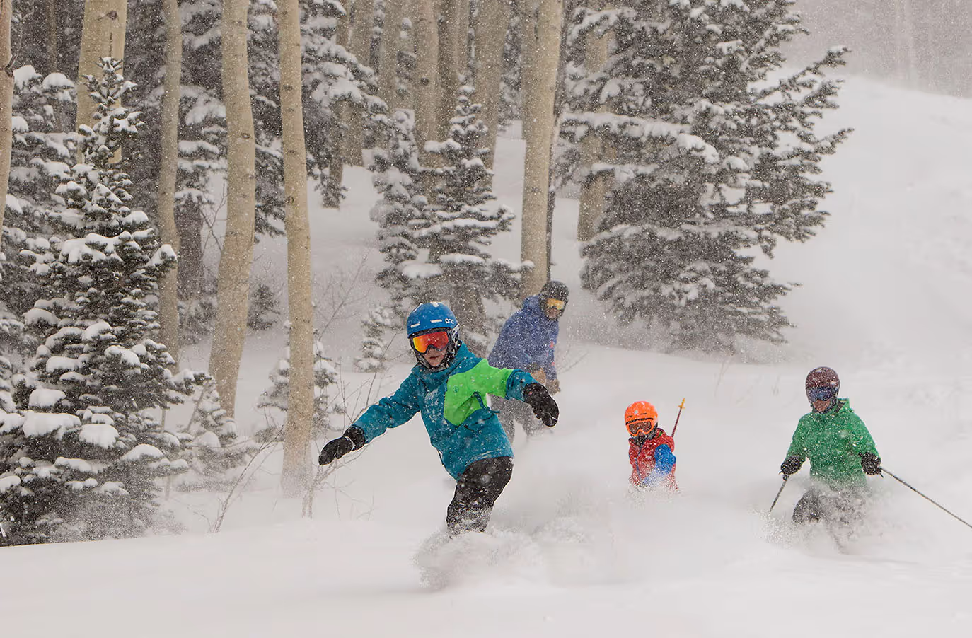 skiers and snowboarder coming down mountain with a lot of snow
