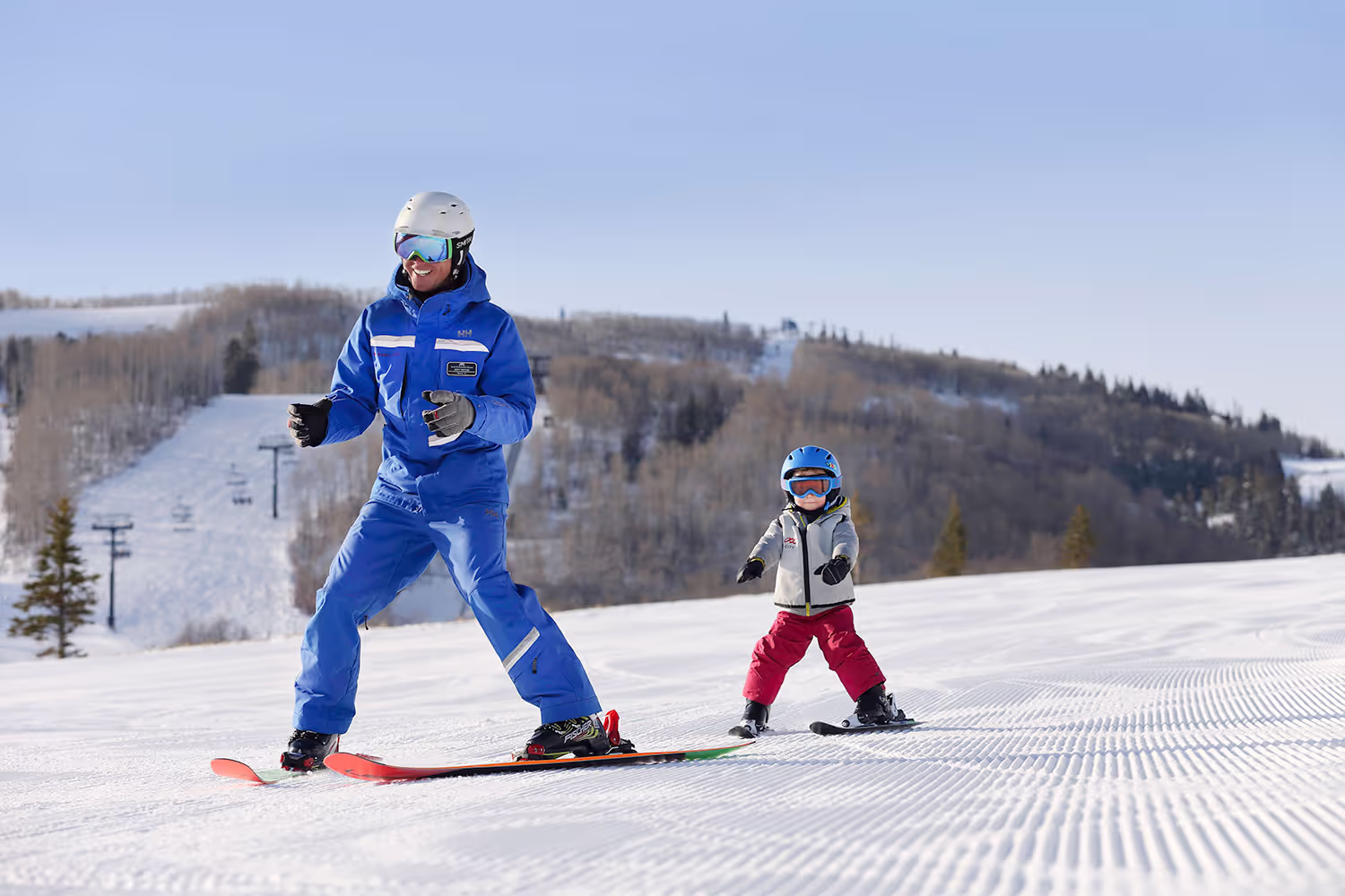 man and small child skiing