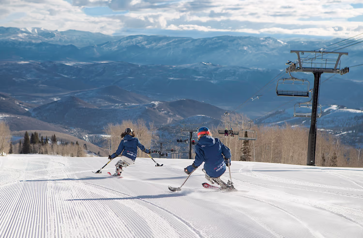 two skiers going down steep mountain
