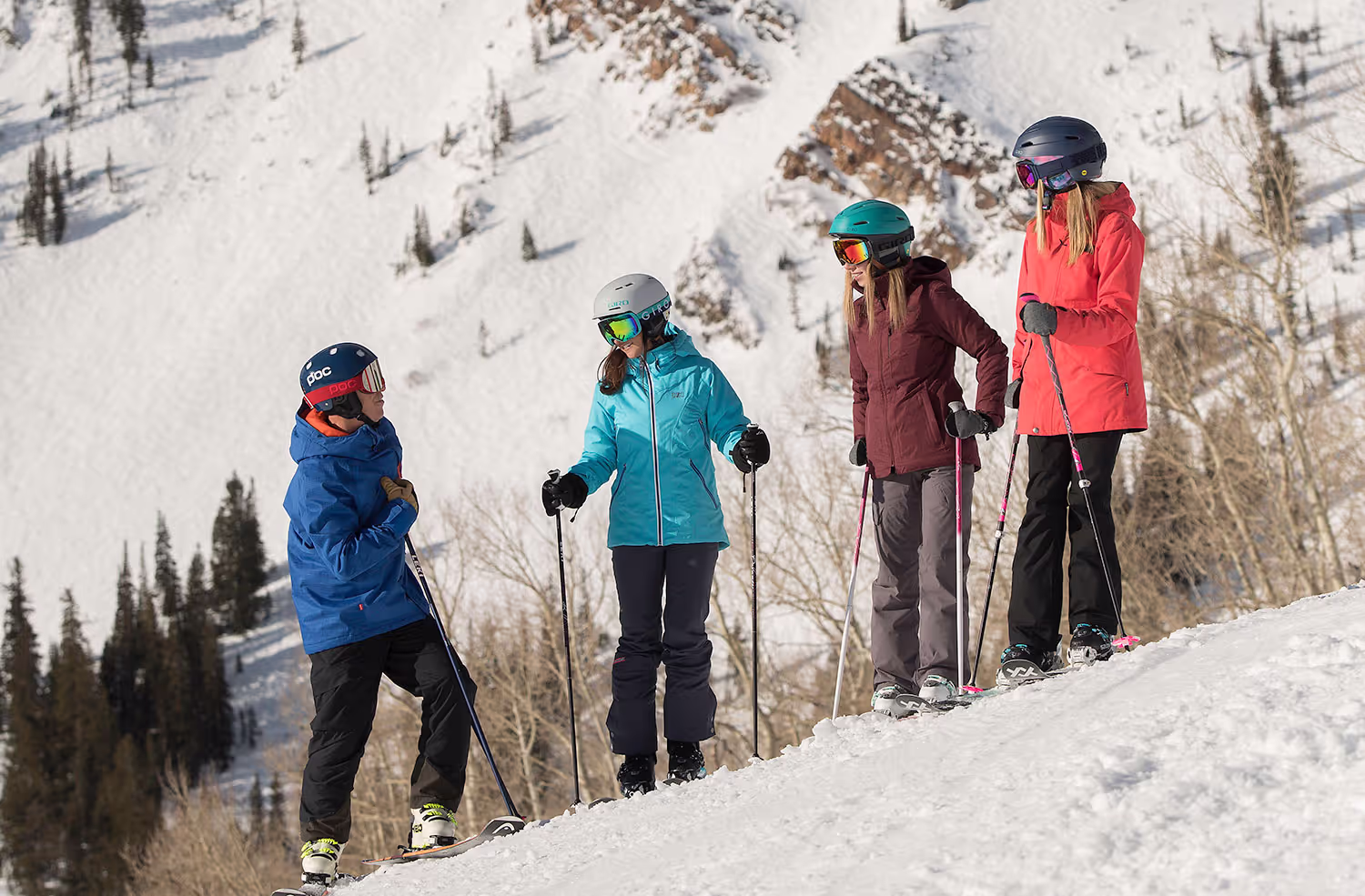 four skiers standing on the mountain
