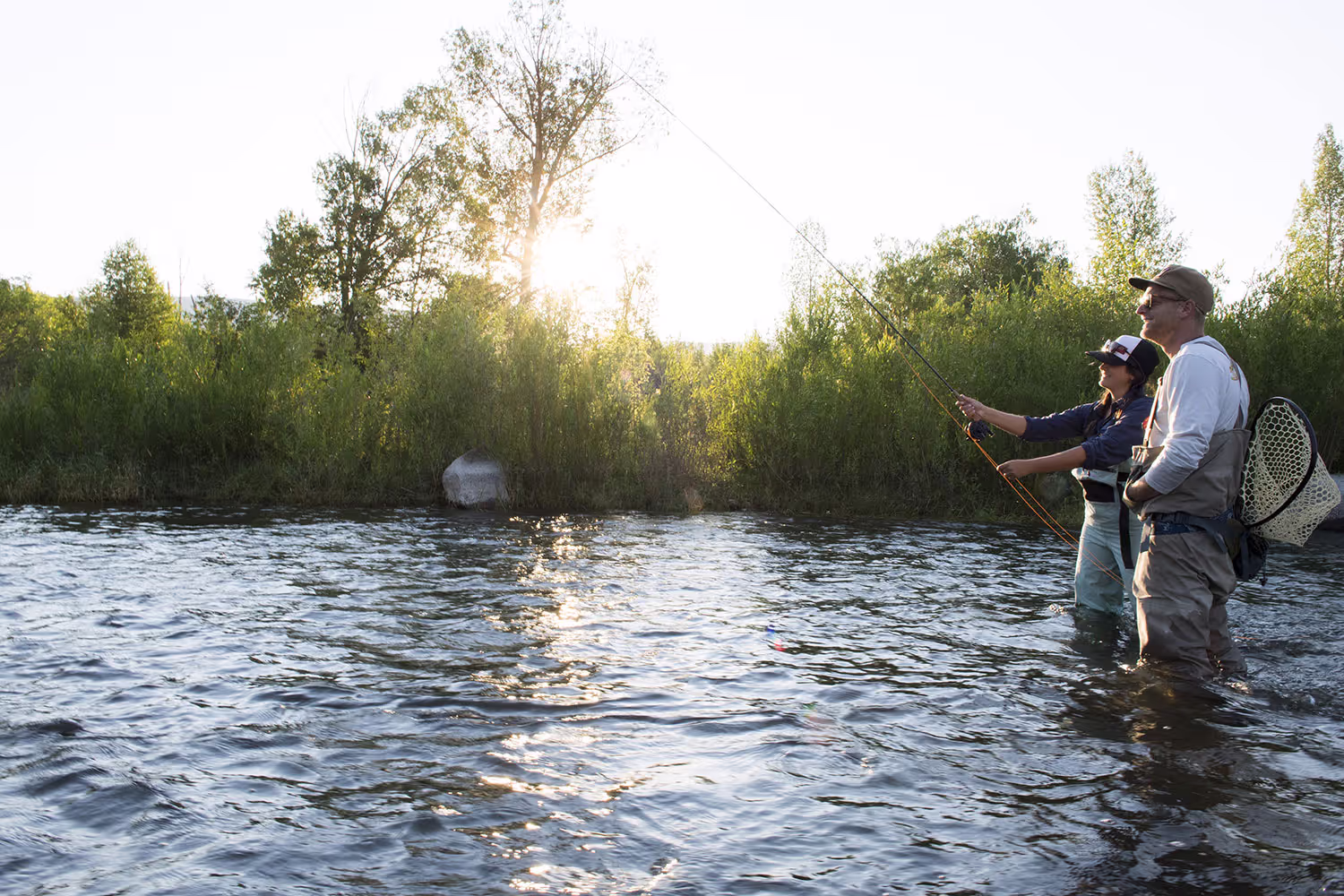 Woman and man fly fishing.