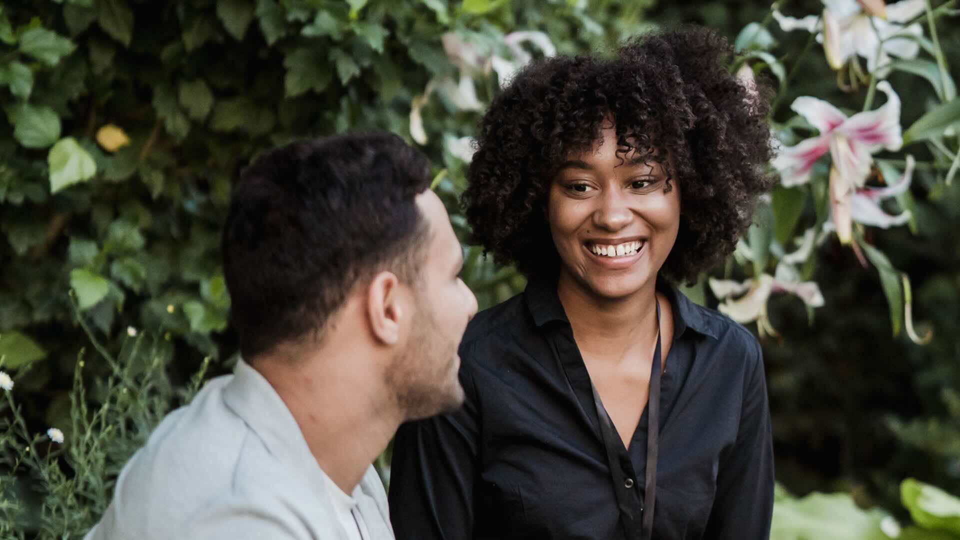 Two people talking in a garden.