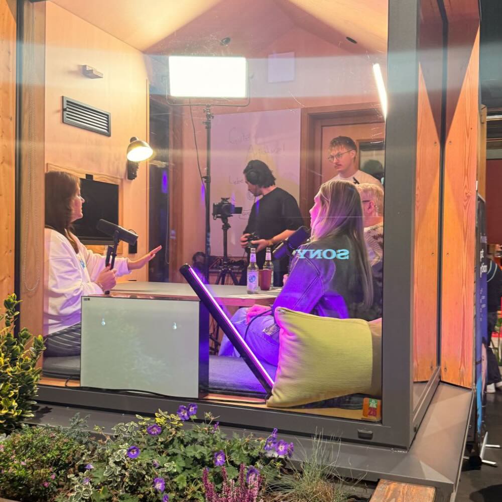 Recording in a sound booth at an event with 2 presenters and producers.
