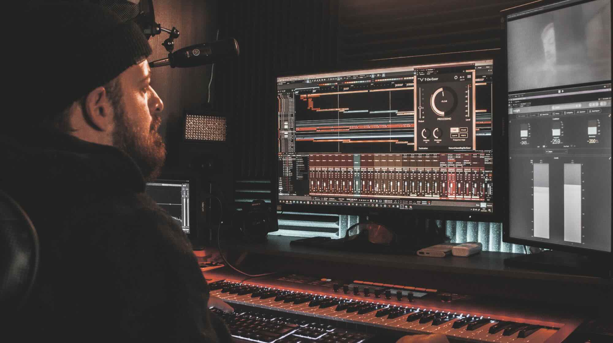 Man editing audio at a mixing desk.