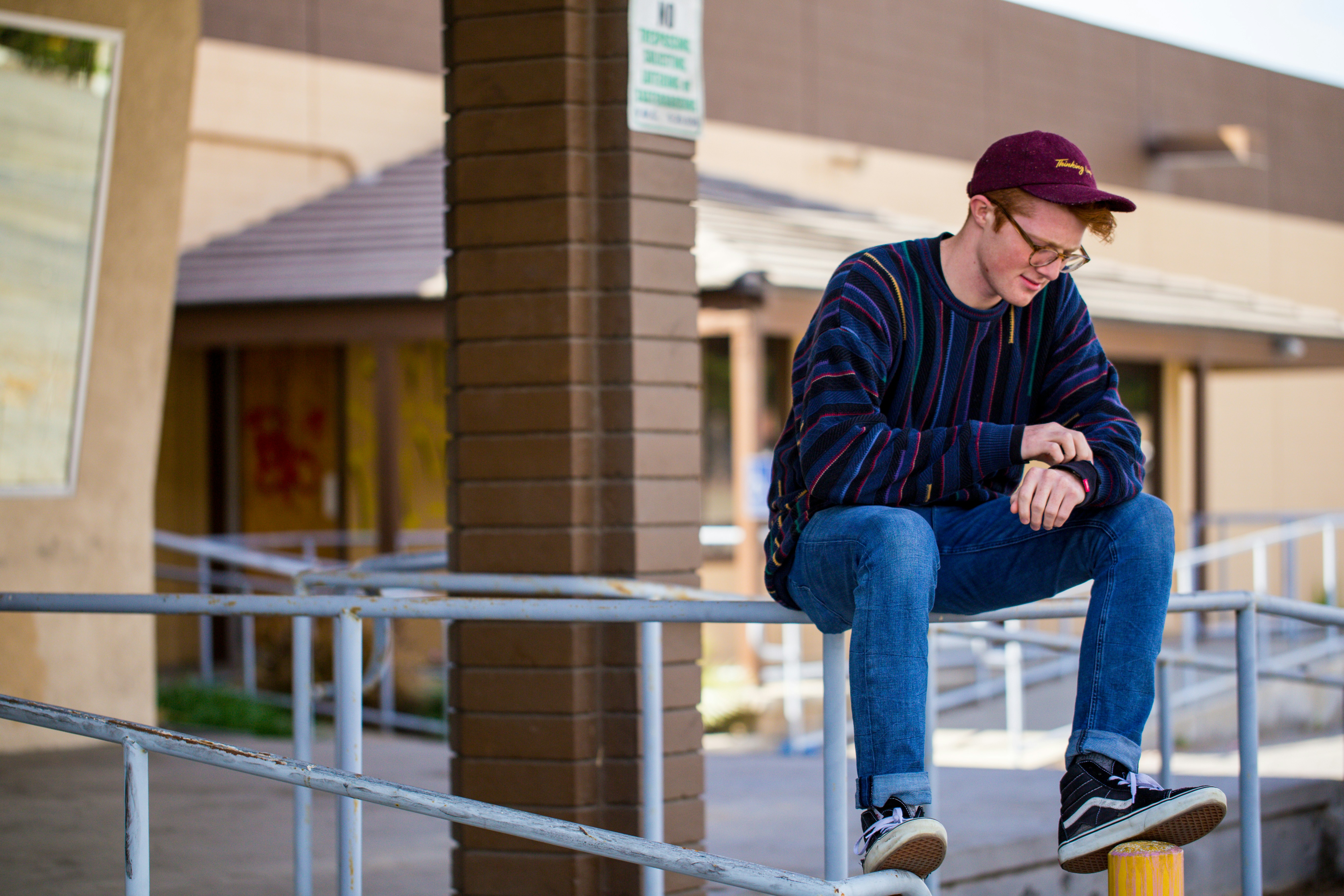 A high school student sits alone outside a school