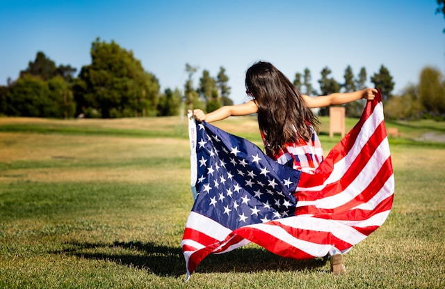 Exchange student running across a field with an American flag