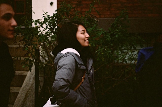 A woman walking down a sidewalk next to a man