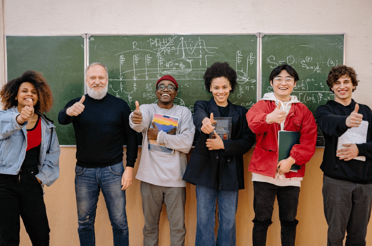 A group of students standing in a classroom smiling at the camera