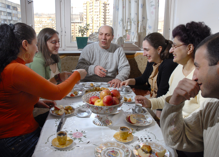 An exchange student and their host family sitting at a table talking
