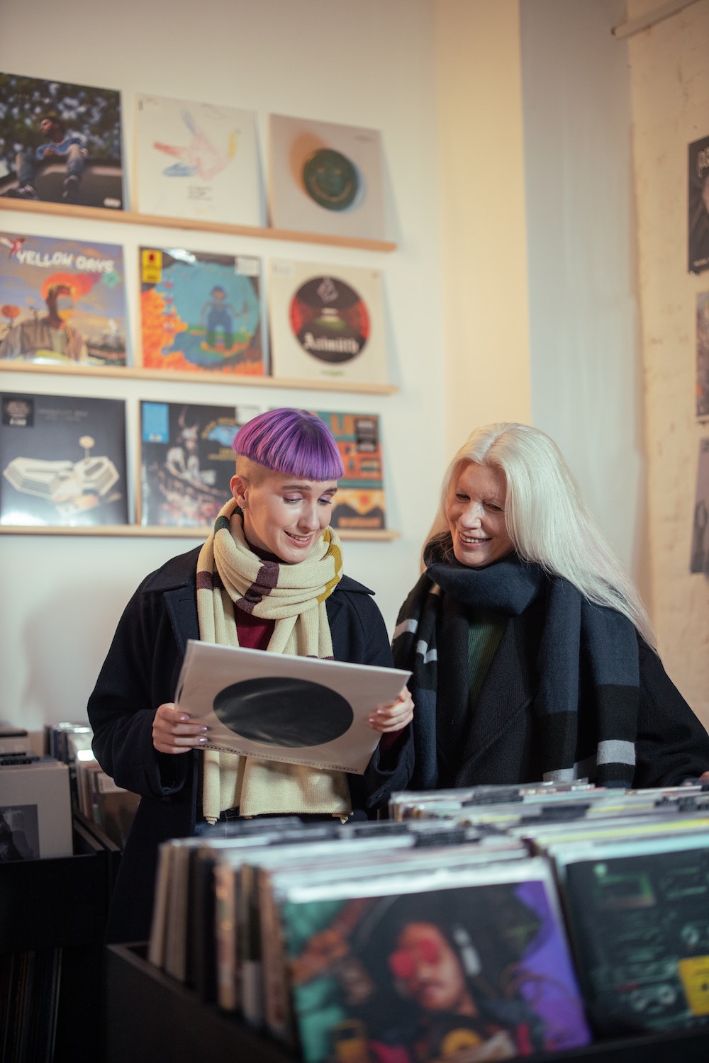 Young person and their host at a record store looking at a vinyl