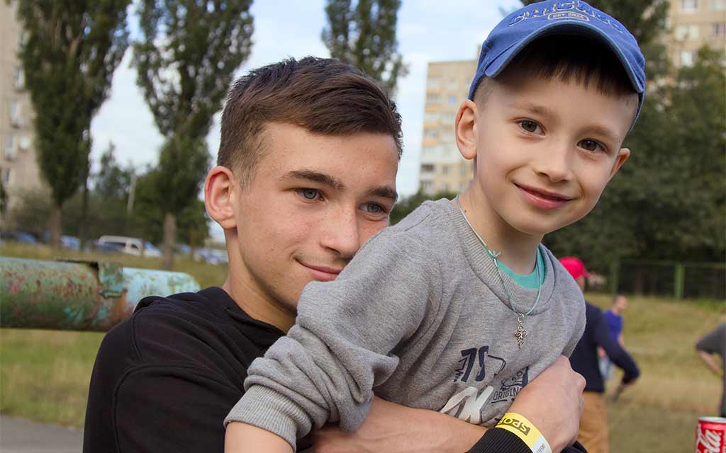 Zwei Jungen umarmen sich bei einem Sportfest während einer Kinderfreizeit von Licht im Osten in Lyssytschansk.
