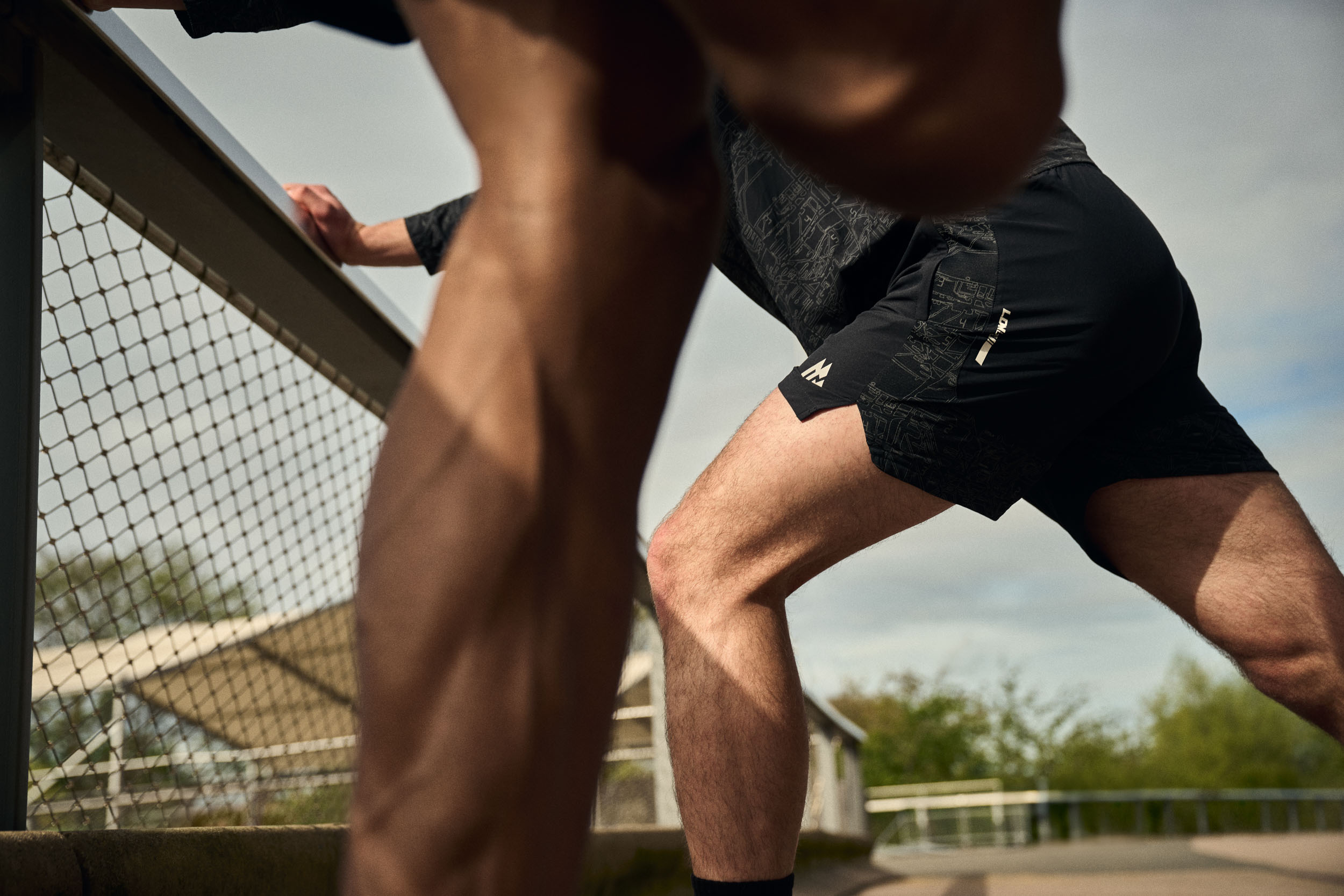 Close crop of Montirex running gear during a stretching sequence near the canal.