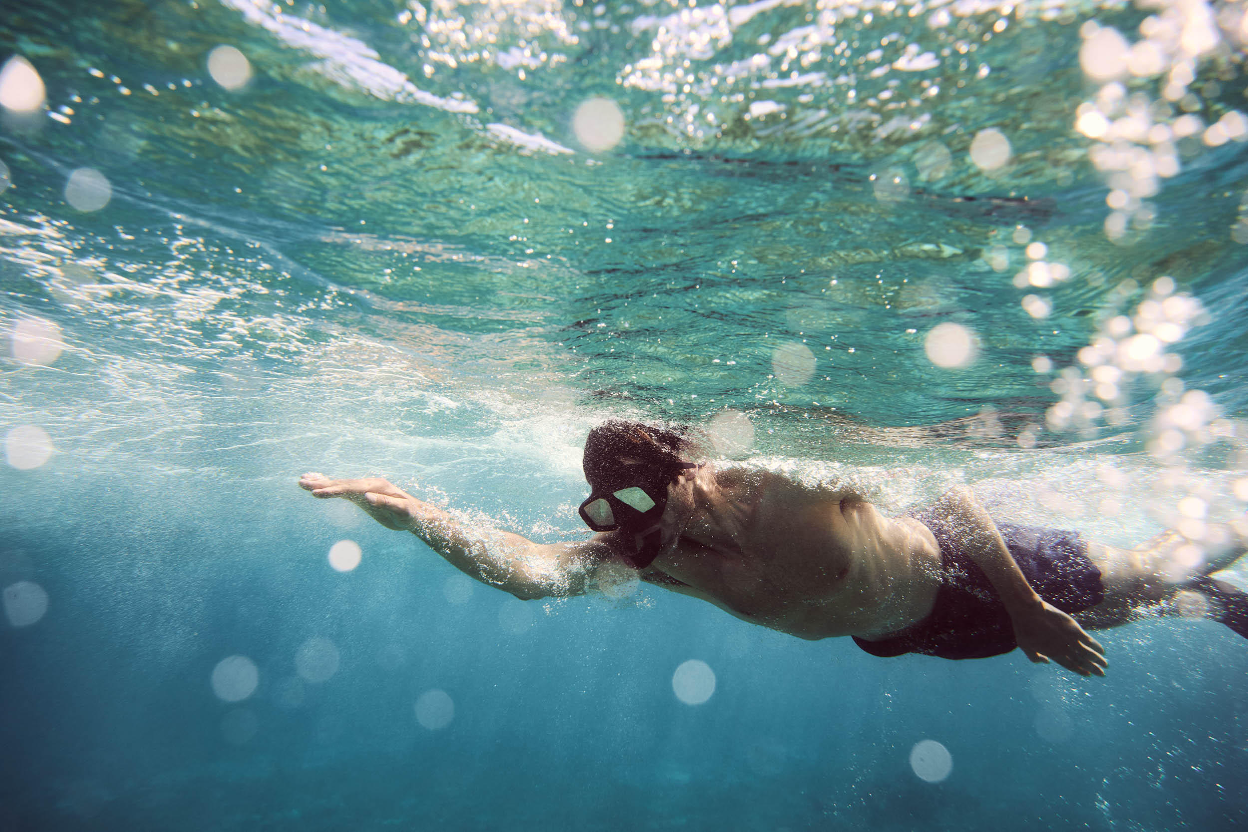 Couple holding hands while snorkelling underwater in Antigua