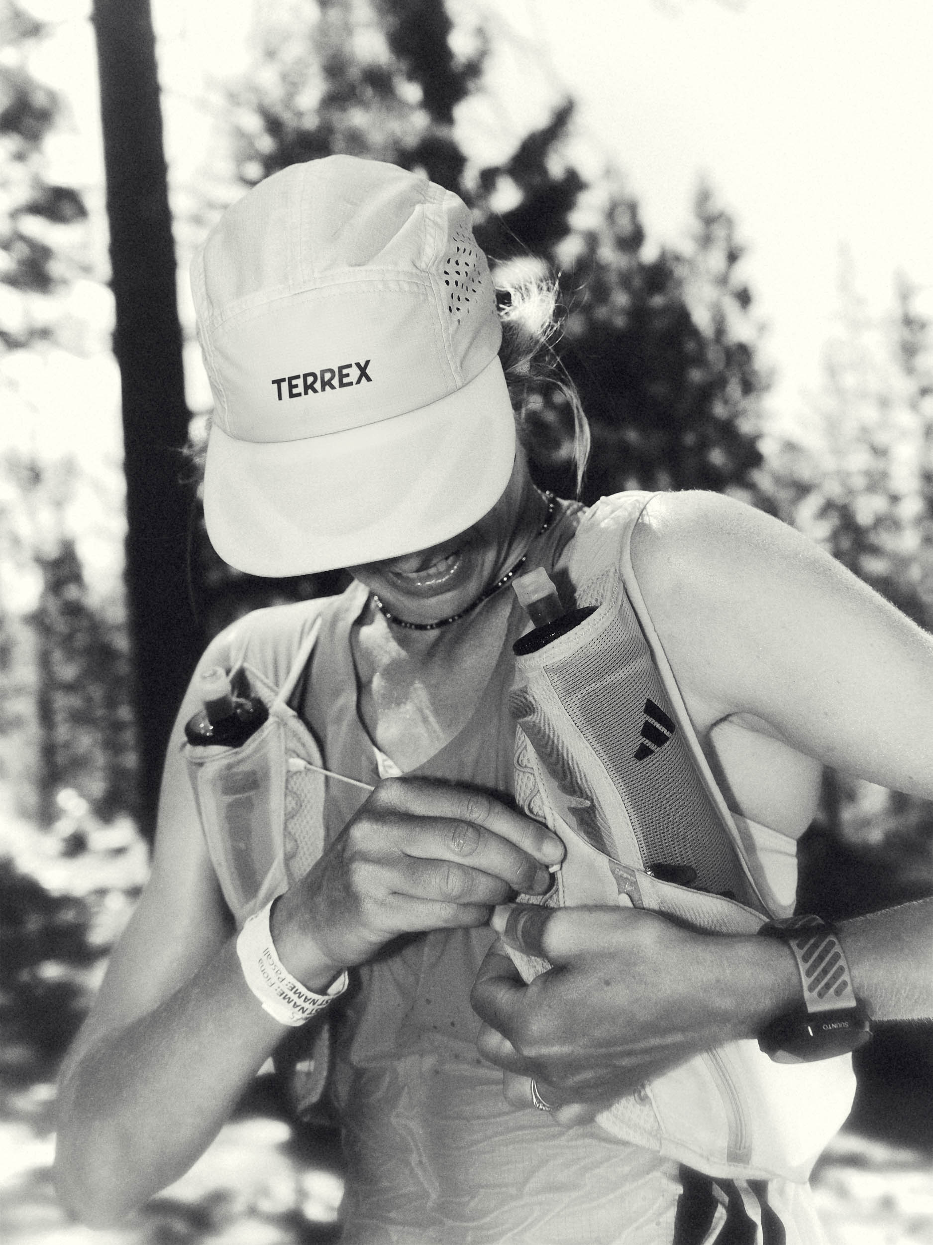 Black-and-white portrait of Fiona Pascall fastening her hydration vest during the race.