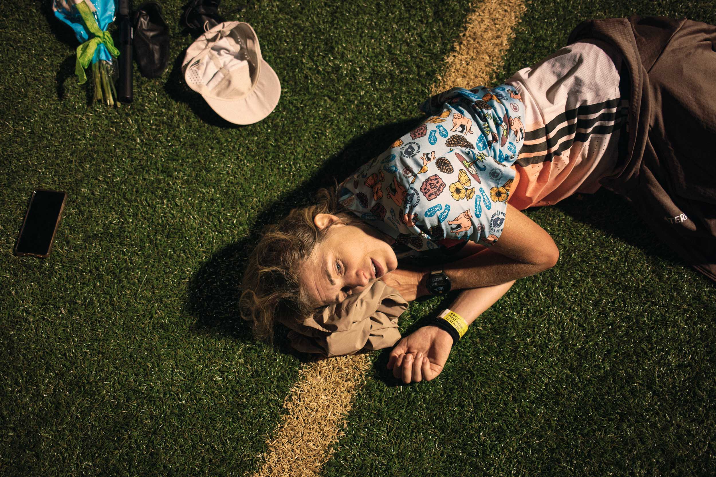 Fiona Pascall lies on the Placer High School track after finishing the 100-mile race.
