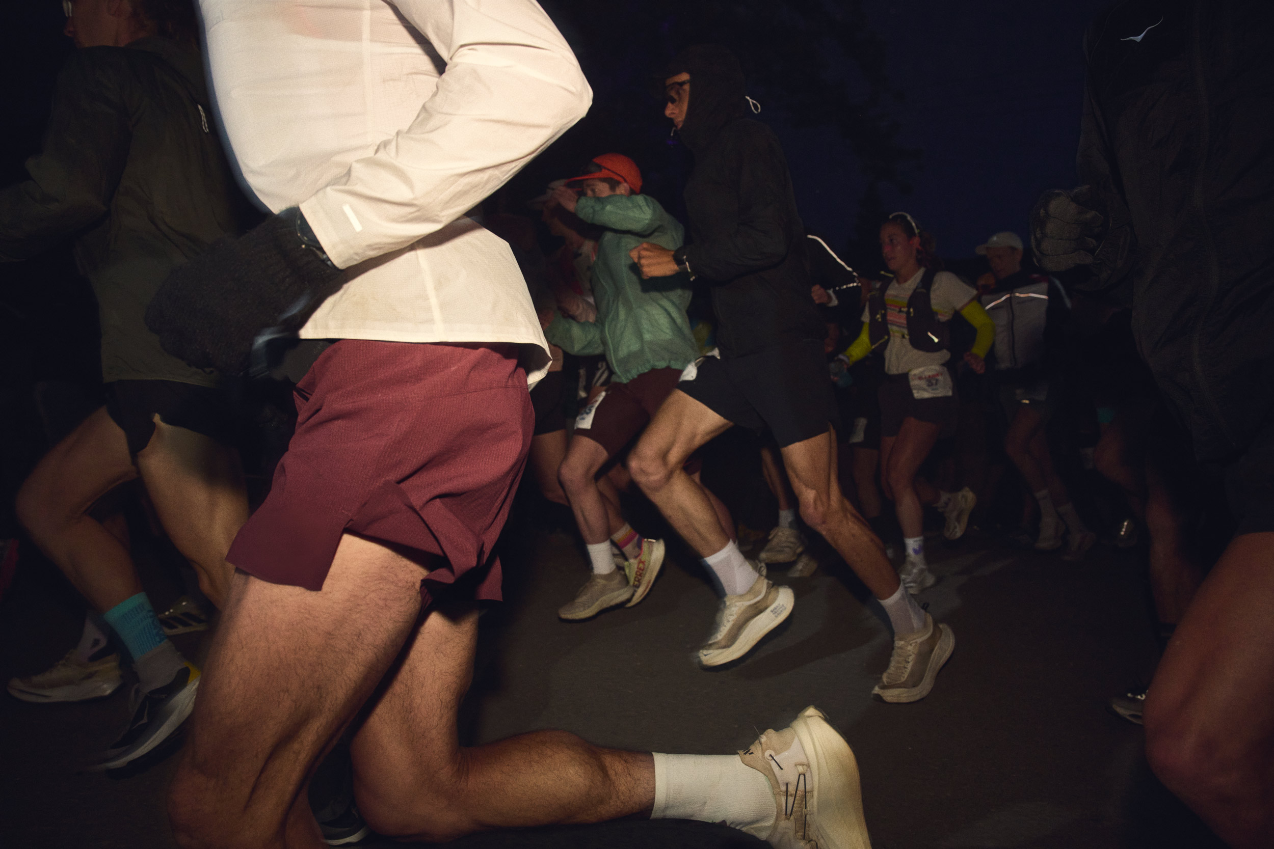 Low-angle view of runners’ legs moving through the dark at the WSER start.