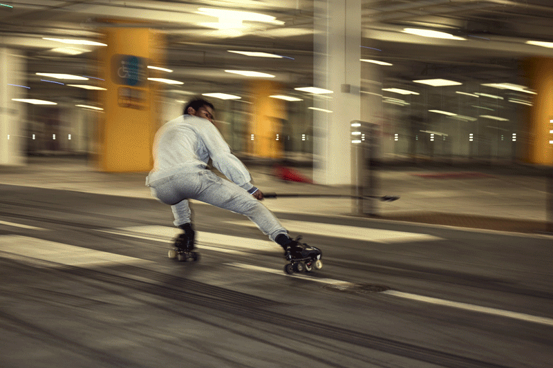 Roller skaters moving through a Vauxhall car park, shot with panning motion blur and light trails.