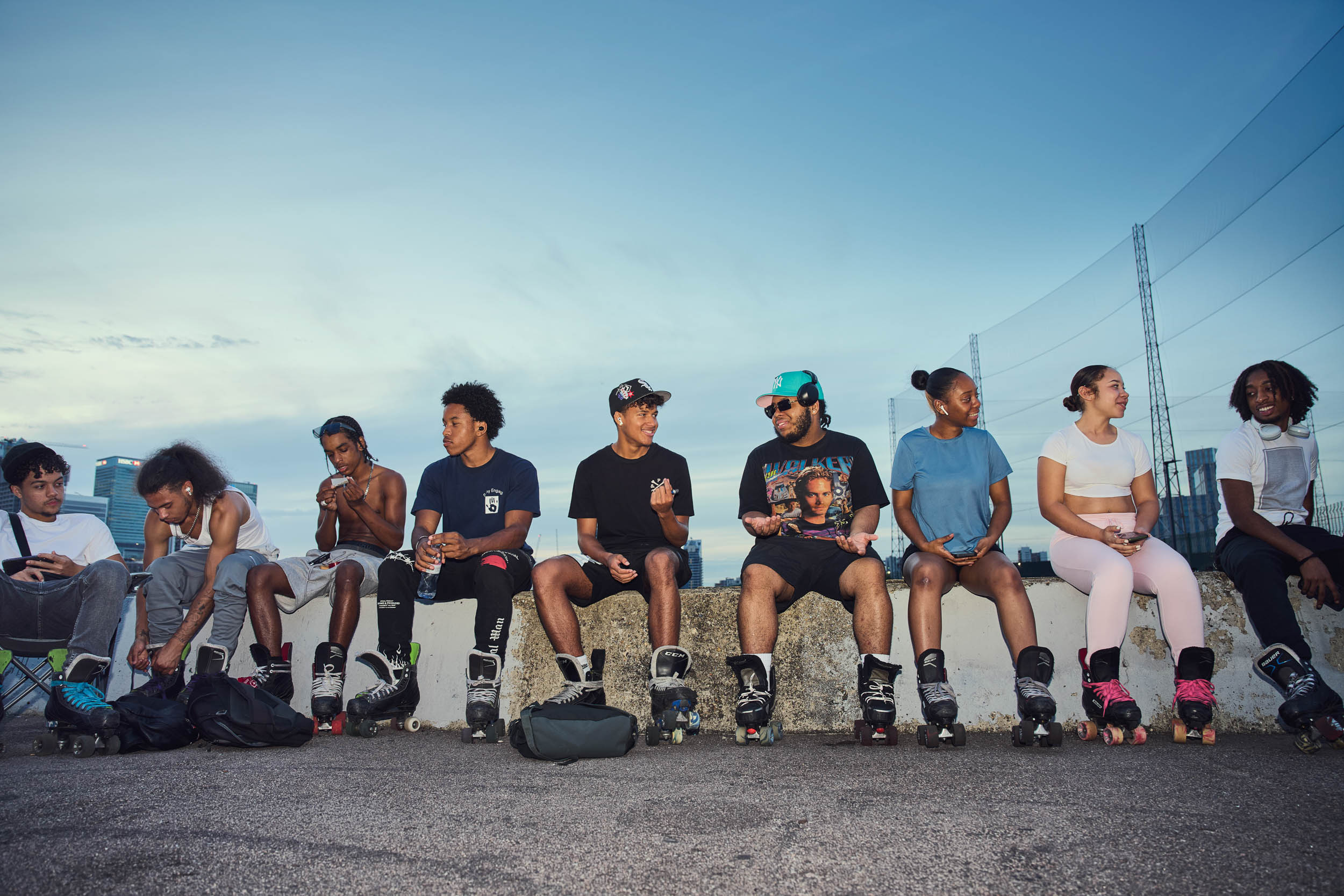 The Greenwich skate community sits along the river wall as the light goes.