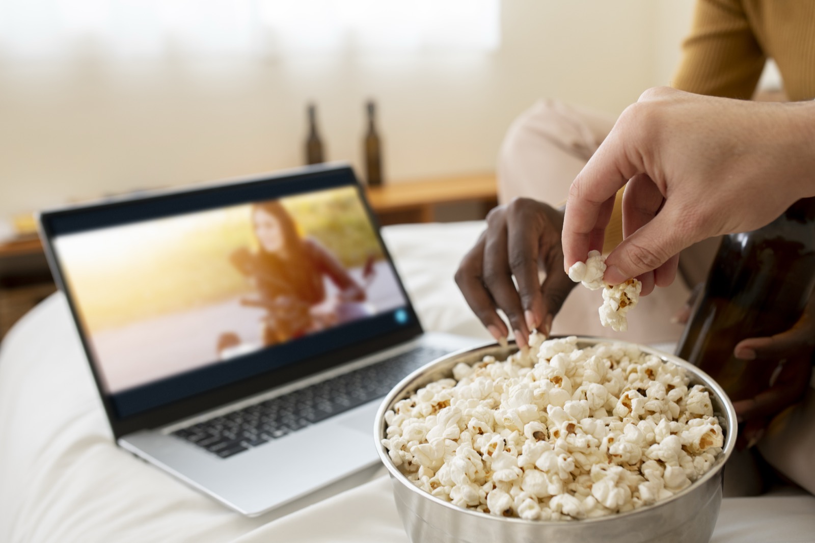 Hands holding popcorn while watching on-demand video