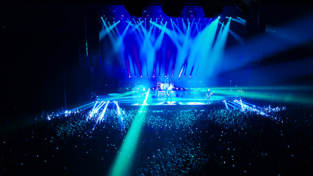 Music channel, now playing — a live concert crowd with raised hands in front of a lit stage