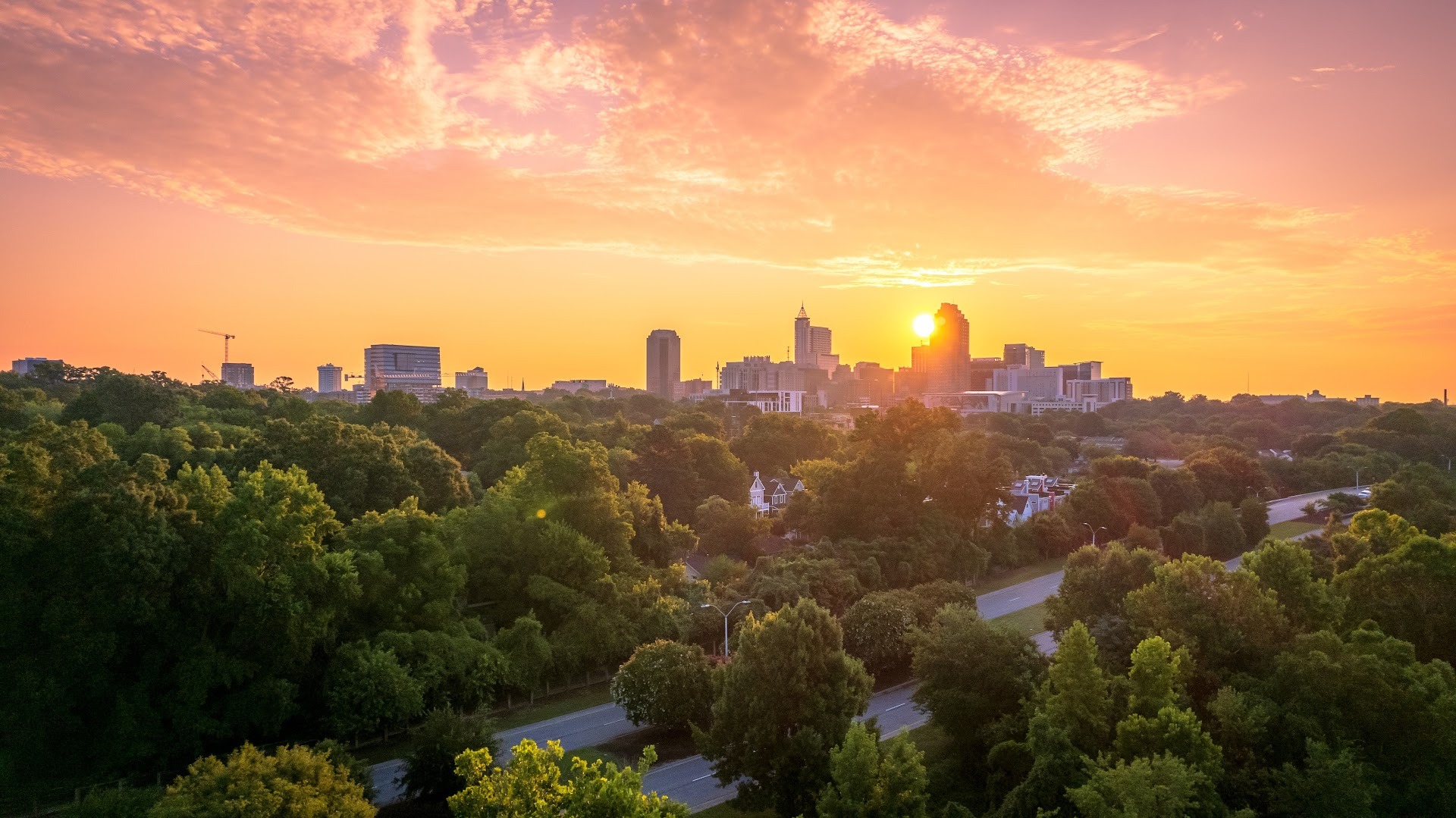 Downtown Raleigh, North Carolina skyline at sunrise with modern buildings and dramatic sky