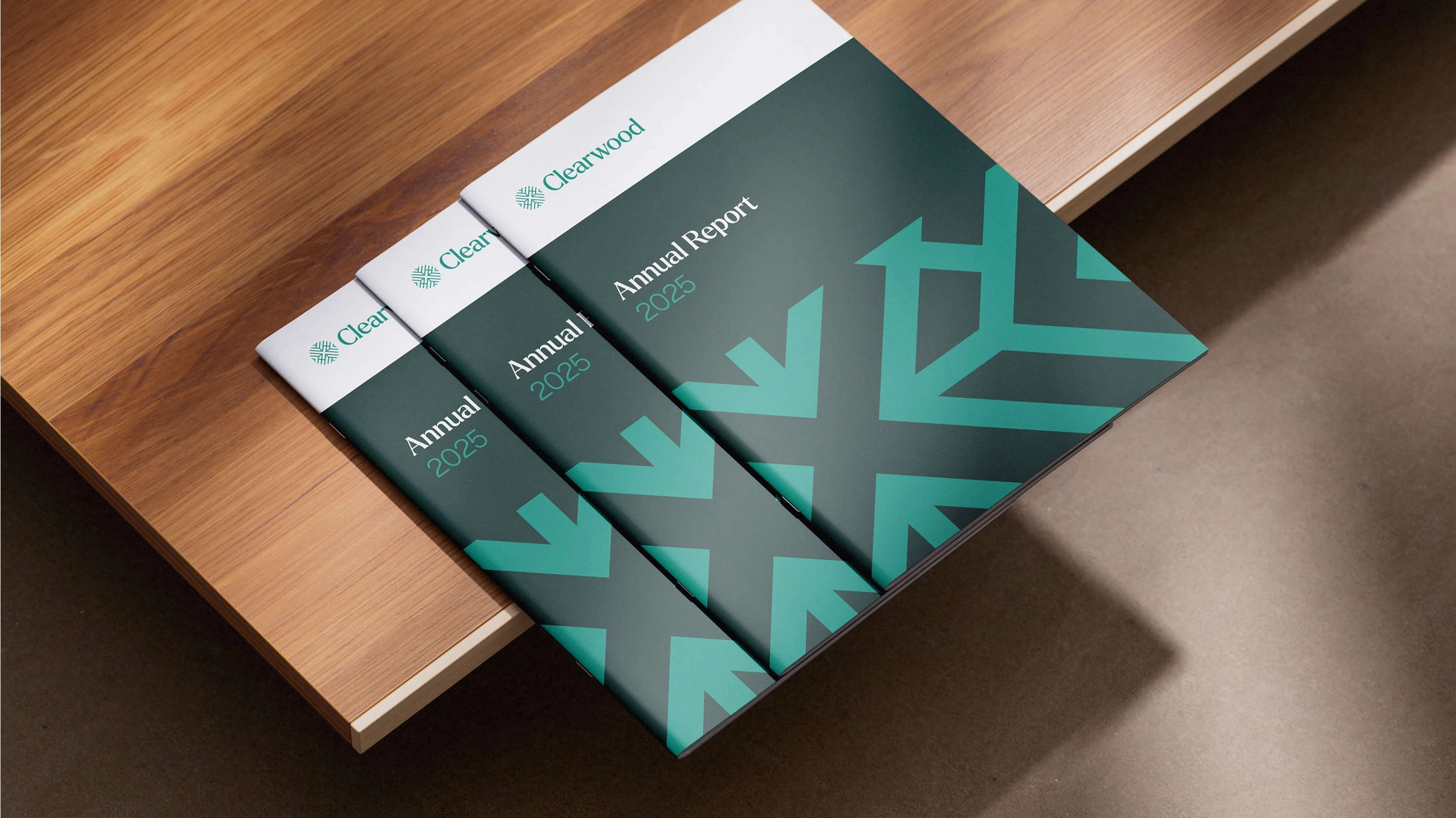 Three annual report covers on a wooden table with jade brand pattern 