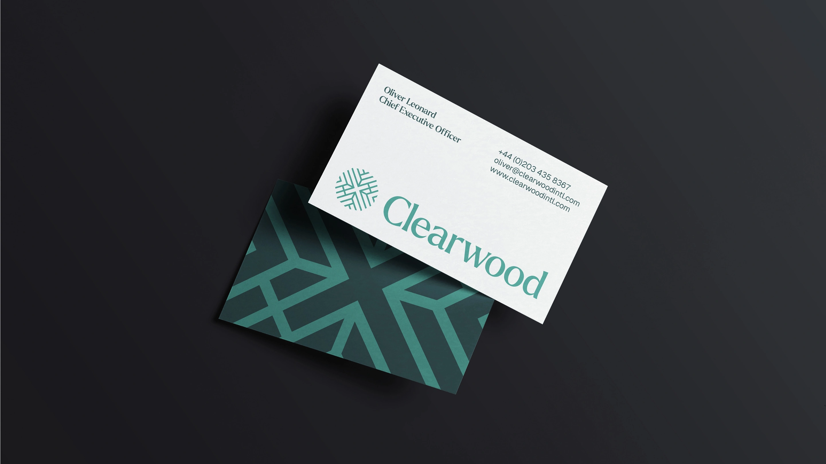 Front and reverse sides of  set of business cards. The reverse shows the brand pattern, whilst the front has an oversized logo and contact details against a white background